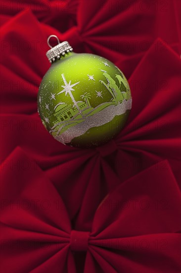 Studio Shot of red velvet bows with green Christmas ornament. Photo : Mike Kemp