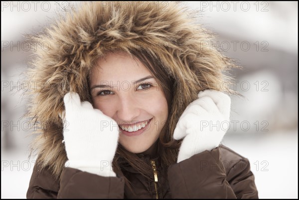 USA, Utah, Lehi, Portrait of young woman wearing fur hooded coat. Photo : Mike Kemp