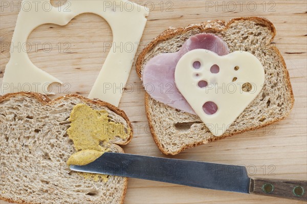 Sandwich with heart shaped slices of meat and cheese.