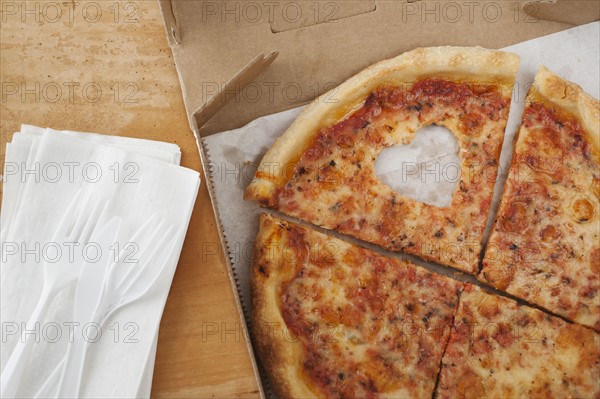 Pizza with missing heart shaped piece.