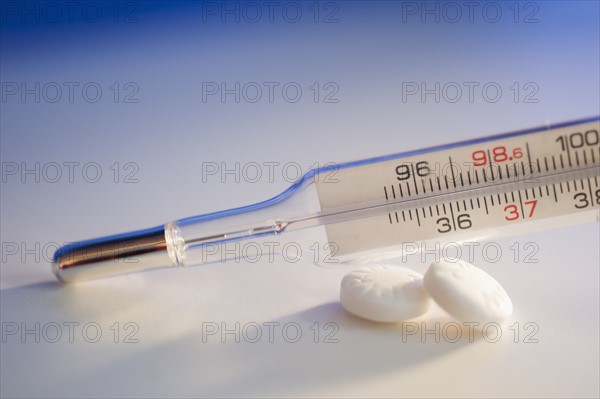 Thermometer and aspirin, close-up.