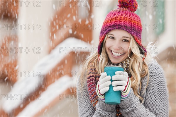 USA, Utah, Salt Lake City, portrait of young woman in winter clothing drinking. Photo : Mike Kemp