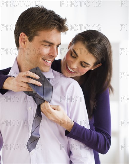 Woman tying men's tie. Photo : Daniel Grill