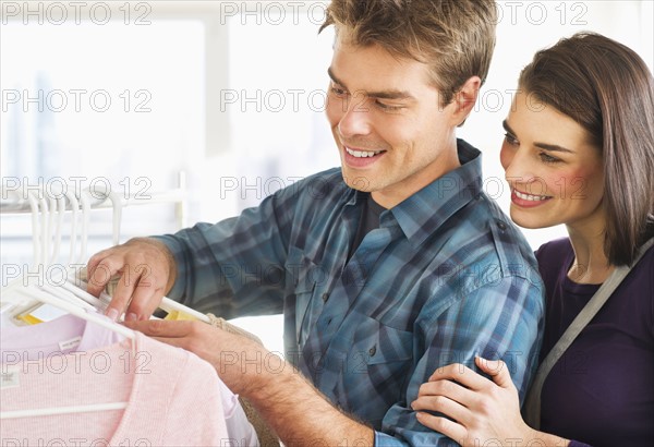 Couple choosing clothes in shop. Photo : Daniel Grill