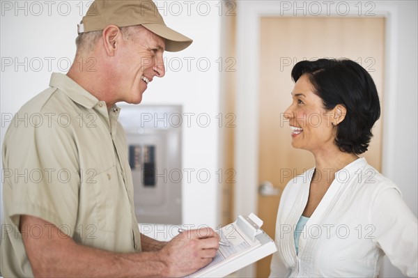 Mature woman talking to technician.