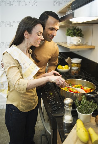 Couple cooking meal in kitchen.