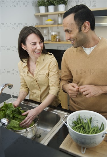 Couple preparing food in kitchen.