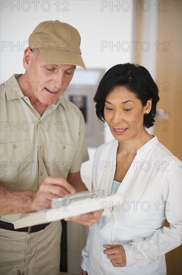 Mature woman talking to technician.