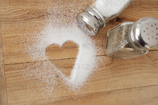 Heart shaped spilt salt on table.