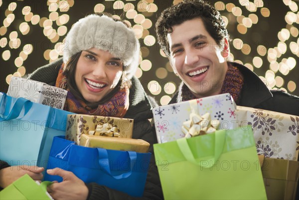 Happy couple holding Christmas presents.