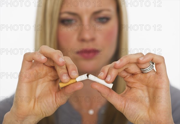 Young woman breaking cigarette. Photo : Daniel Grill