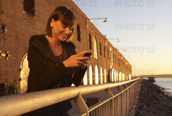 USA, New York City, Brooklyn, woman using cell phone. Photo : Shawn O'Connor