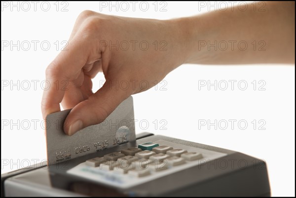 Studio shot of hand using credit card. Photo : Mike Kemp