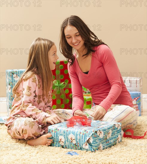 Two sisters (6-7, 18-19) wrapping Christmas presents. Photo : Mike Kemp