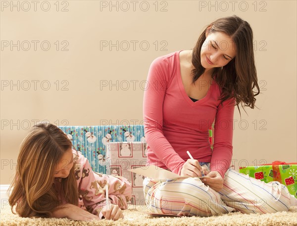 Two sisters (6-7, 18-19) wrapping Christmas presents. Photo : Mike Kemp