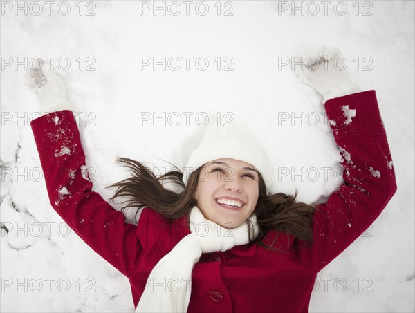 USA, Utah, Lehi, Young woman lying in snow. Photo : Mike Kemp