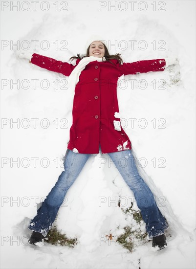 USA, Utah, Lehi, Portrait of young woman lying in snow. Photo : Mike Kemp