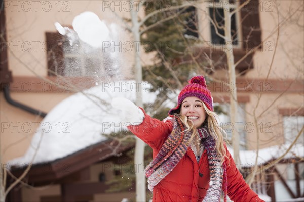 USA, Utah, Salt Lake City, Portrait of young woman throwing snowball. Photo : Mike Kemp