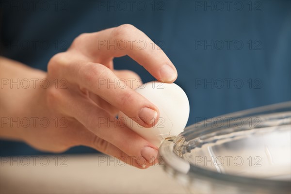 Womans hands cracking egg. Photo : Mike Kemp
