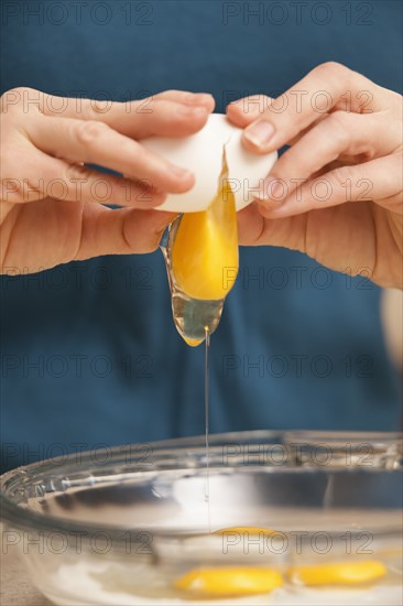 Womans hands cracking eggs. Photo : Mike Kemp