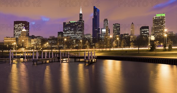 USA, Illinois, Chicago, City skyline and marina illuminated at dusk. Photo : Henryk Sadura