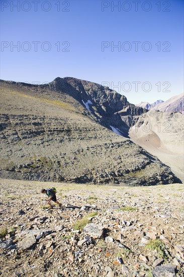 USA, Montana, Glacier National Park, Mid adult man hiking . Photo : Noah Clayton