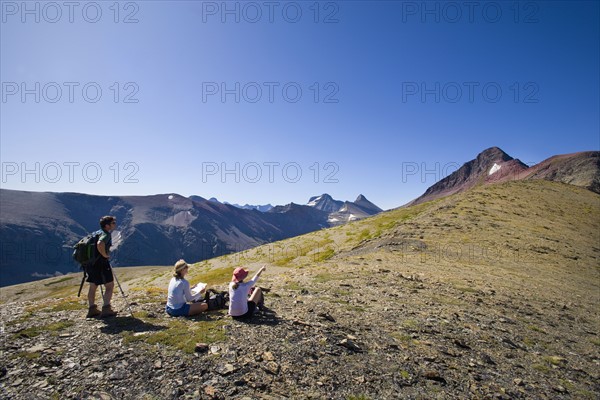 USA, Montana, Glacier National Park, Hikers resting on top. Photo : Noah Clayton