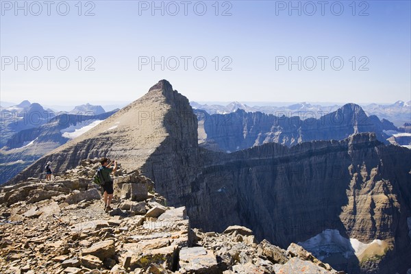 USA, Montana, Glacier National Park, Hikers taking pictures at top of Mt Siyeah. Photo : Noah Clayton
