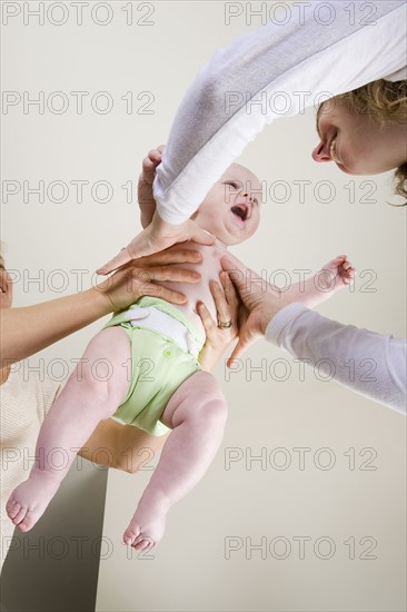 Parents holding baby boy (6-11 months). Photo : Noah Clayton