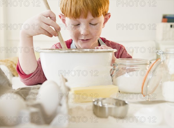 Portrait of boy (8-9) preparing cake. Photo : Jamie Grill Photography