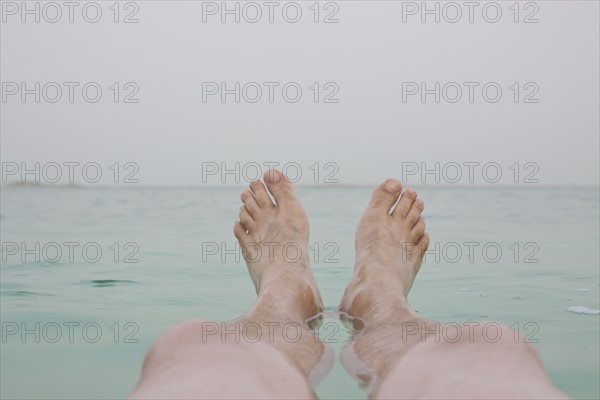 Israel, Dead Sea, mature men's legs in sea. Photo : Johannes Kroemer