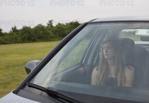 USA, New York State, Long Island, young woman sitting in car. Photo : Johannes Kroemer