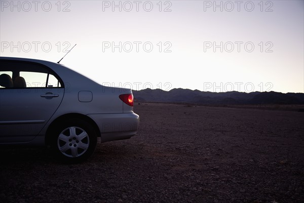 USA, Nevada, car on desert road at dusk. Photo : Johannes Kroemer