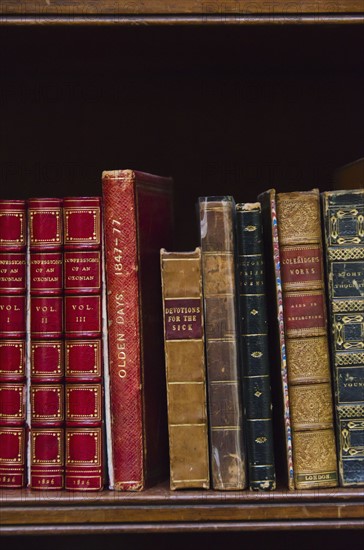 Close up of antique books on shelf.