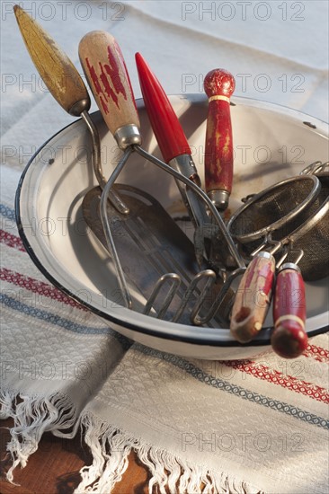 Antique cooking utensils in bowl.