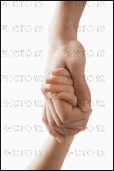 Studio shot of hands of woman and girl (2-3). Photo : Mike Kemp