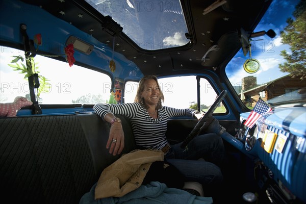 USA, Colorado, Carbondale, Smiling mature woman sitting in vintage car, portrait. Photo : Noah Clayton