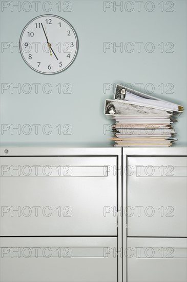 Stack of documents on filing cabinet.