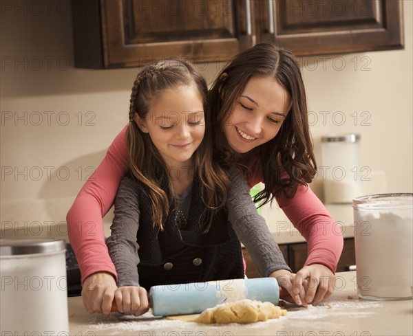 Two sisters (6-7, 18-19) rolling dough. Photo : Mike Kemp