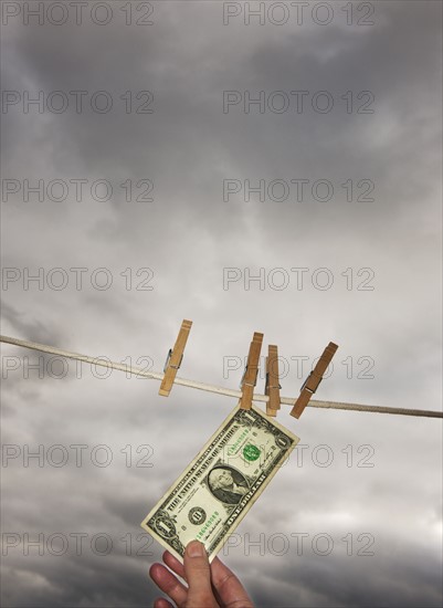 One dollar banknote drying on clothline.