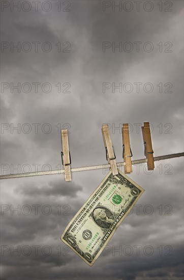 One dollar banknote drying on clothline.