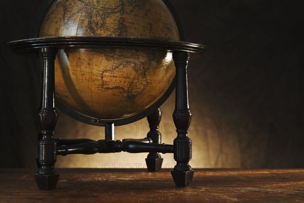 Close up of antique globe on table.