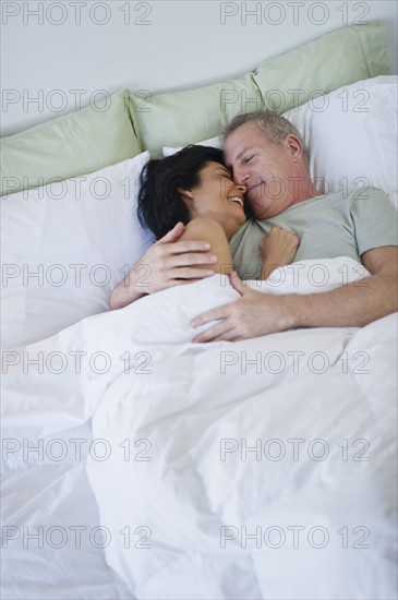 Happy mature couple laying in bed.
