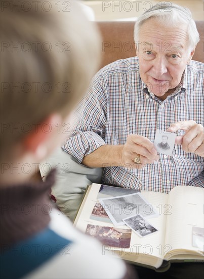 Grandfather and grandson (8-9) watching family photos. Photo : Jamie Grill Photography