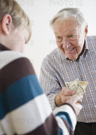 Grandson (8-9) receiving allowance from Grandfather. Photo : Jamie Grill Photography