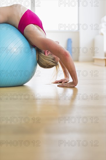 Woman exercising on fitness ball. Photo : Daniel Grill