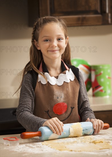 Portrait of girl (6-7) rolling dough. Photo : Mike Kemp