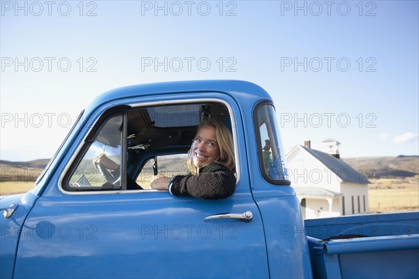 USA, Colorado, Carbondale, Cowgirl driving old fashioned pickup truck. Photo : Noah Clayton