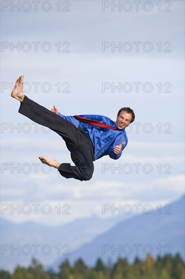 USA, Montana, Whitefish, businessman performing high kick mid-air. Photo : Noah Clayton