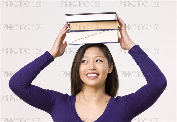 Female student carrying book on head. Photo : Dan Bannister